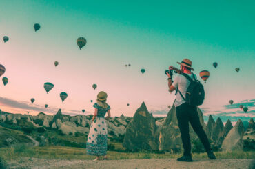 Man taking photo of hot air balloons